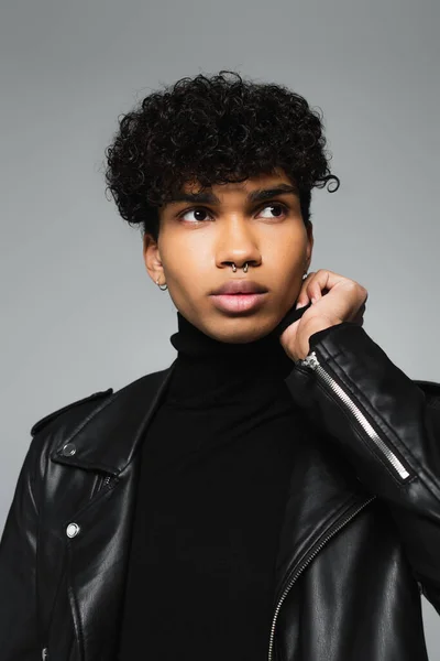 Stylish african american man in black turtleneck and leather jacket looking away isolated on grey — Foto stock