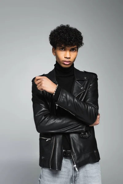 African american man with trendy hairstyle, wearing leather jacket, posing isolated on grey — Foto stock