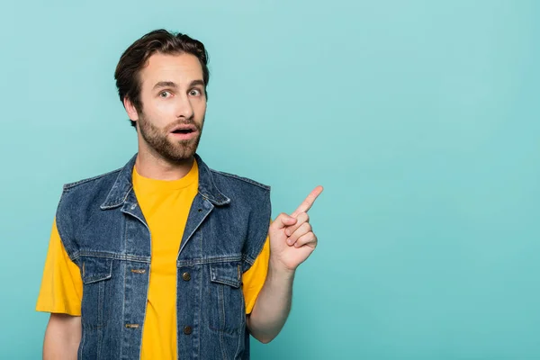 Amazed man pointing with finger isolated on blue — Stock Photo