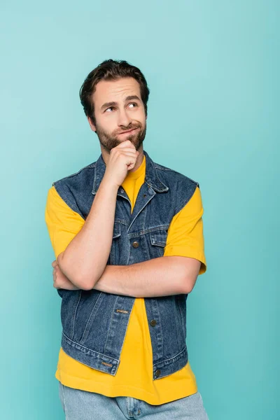 Pensive brunette man looking up isolated on blue — Stock Photo