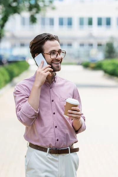 Gerente com café para ir falar no celular ao ar livre — Fotografia de Stock