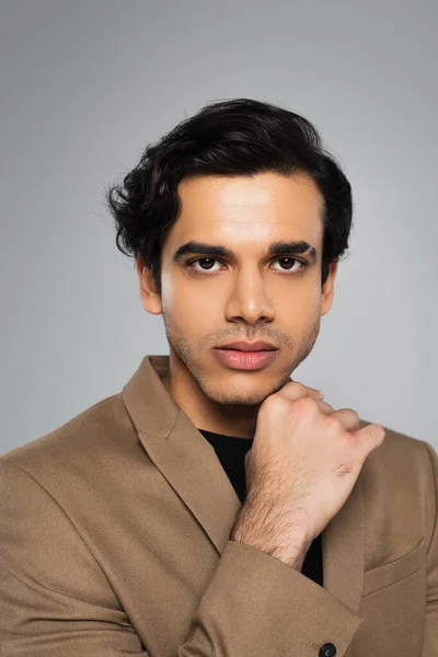 Young man in blazer looking at camera while posing isolated on grey — Stock Photo