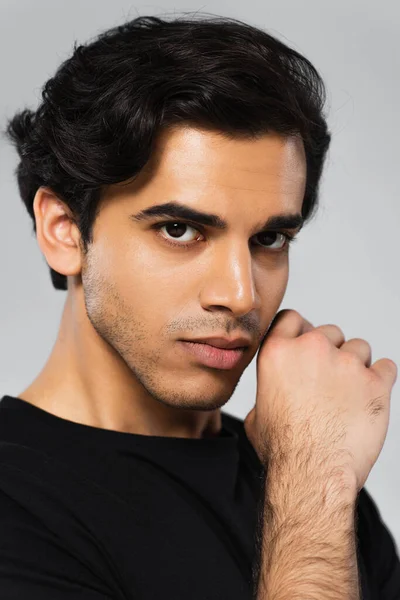 Joven serio hombre en negro camiseta posando aislado en gris - foto de stock