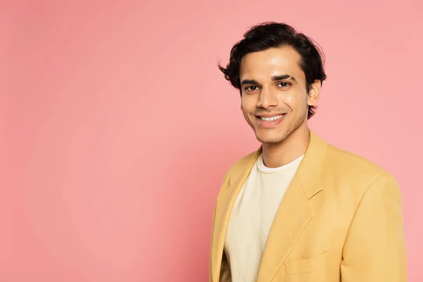 Heureux jeune homme en blazer jaune souriant sur rose — Photo de stock