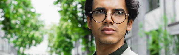 Young man in eyeglasses looking away outside, banner — Stock Photo