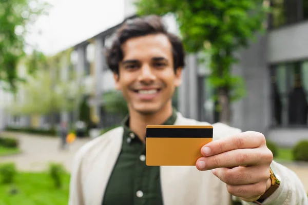 Щасливий і розмитий чоловік тримає кредитну картку зовні — стокове фото
