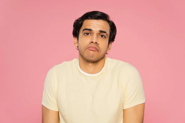 Confused man showing shrug gesture isolated on pink — Stock Photo