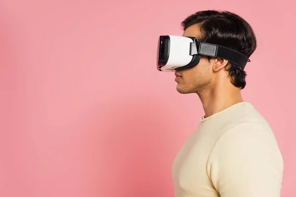 Vue latérale du jeune homme en casque vr isolé sur rose — Photo de stock