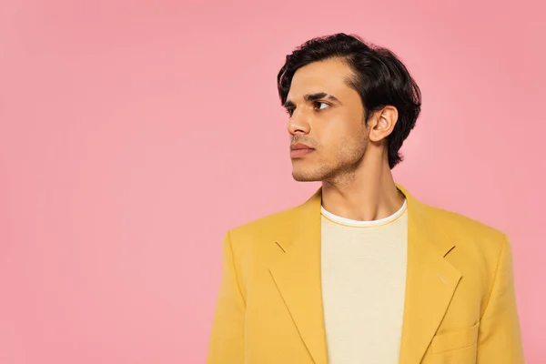 Joven con estilo en blazer de moda mirando hacia otro lado aislado en rosa — Stock Photo