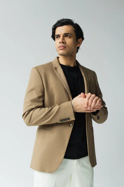 Jeune homme en élégant blazer beige regardant loin isolé sur gris — Photo de stock