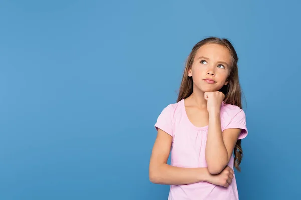 Criança pensativa em camiseta rosa olhando para longe isolado em azul — Fotografia de Stock
