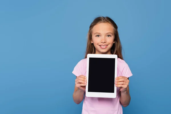 Усміхнена дівчина тримає цифровий планшет ізольовано на синьому — стокове фото