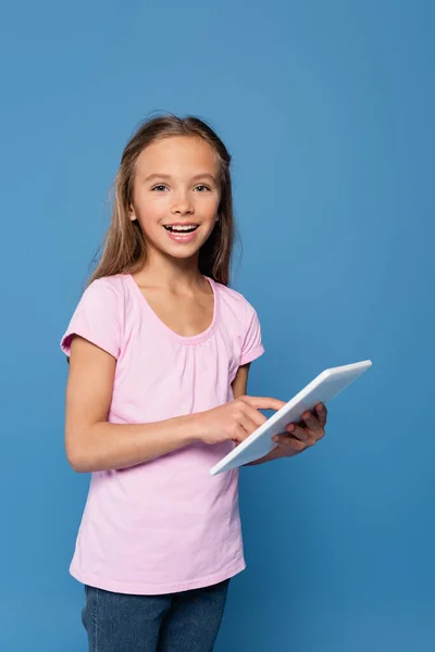 Menina com tablet digital sorrindo para a câmera isolada em azul — Fotografia de Stock