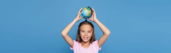 Sourire enfant tenant globe au-dessus de la tête isolé sur bleu, bannière — Photo de stock