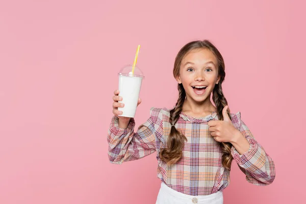 Kind mit Milchshake zeigt Geste auf rosa — Stockfoto