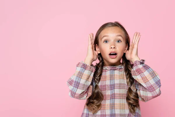 Schockiertes Mädchen in karierter Bluse blickt isoliert auf rosa Kamera — Stockfoto