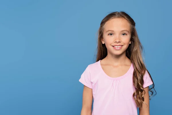 Menina feliz em t-shirt branca sorrindo para a câmera isolada em azul — Fotografia de Stock