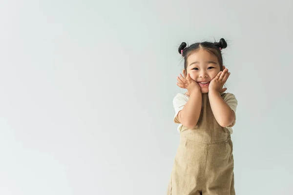 Щаслива азіатська дівчинка-малюк посміхається ізольовано на сірому — стокове фото