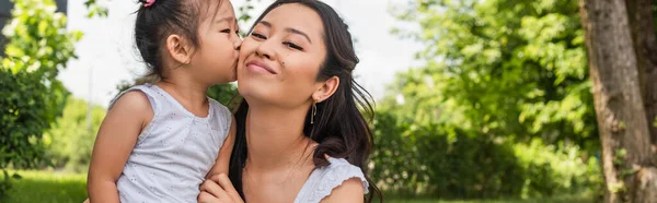 Asiatische Kleinkind Mädchen küsst Wange der glücklichen Mutter im Park, Banner — Stockfoto