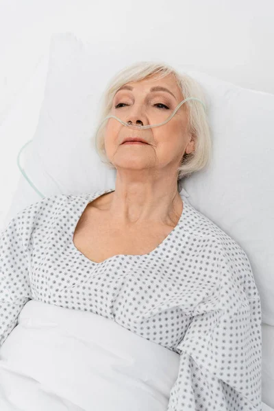 Літній пацієнт з носовою канюлею лежить на лікарняному ліжку — стокове фото