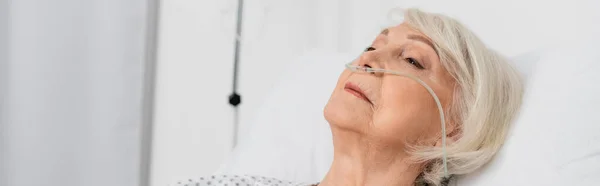 Старшая женщина с носовой канюлей лежит на кровати в больнице, баннер — стоковое фото