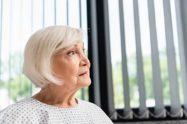 Senior woman looking away in hospital ward — Stock Photo