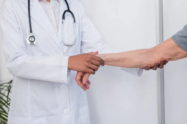 Vista cortada de afro-americano médico tocando braço de paciente idoso — Fotografia de Stock