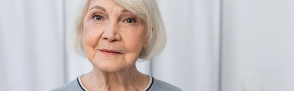 Senior woman looking at camera in clinic, banner — Stock Photo