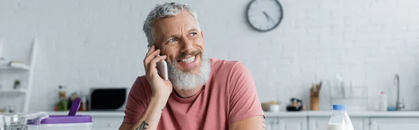 Lächelnder Mann spricht auf Smartphone in Küche, Banner — Stockfoto