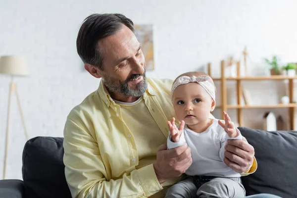 Positive mature man holding baby daughter — Stock Photo