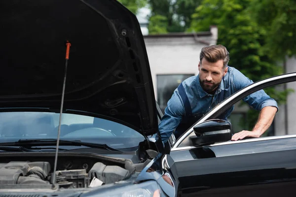 Mechaniker steht neben Autotür im Freien — Stockfoto