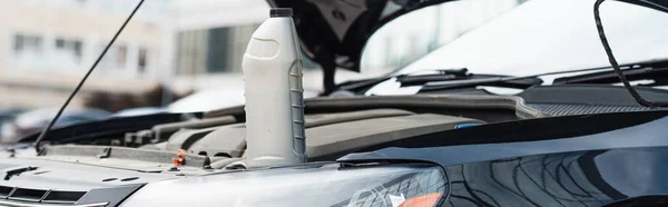 Flasche Motoröl auf Auto mit offener Motorhaube, Banner — Stockfoto