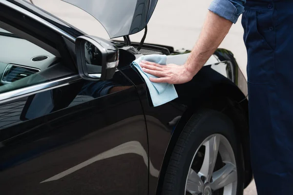 Cropped view of mechanic wiping car with rag outdoors — Stock Photo