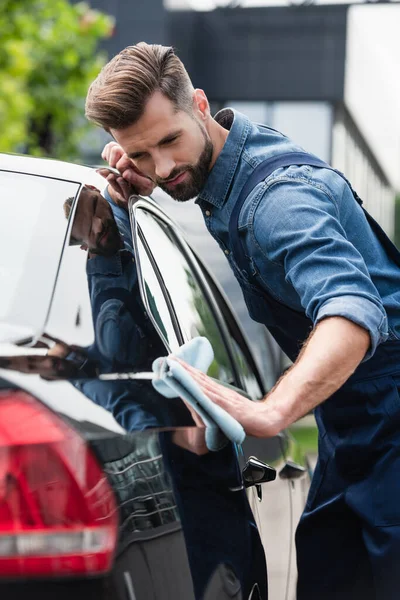 Mechanic waxing car on blurred foreground outdoors — Stock Photo