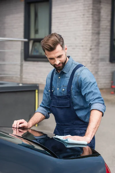 Brünette Mechaniker mit Lappen Wachsen Auto im Freien — Stockfoto