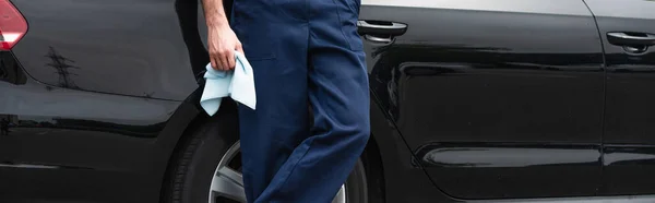 Cropped view of mechanic holding rag near clean auto outdoors, banner — Stock Photo