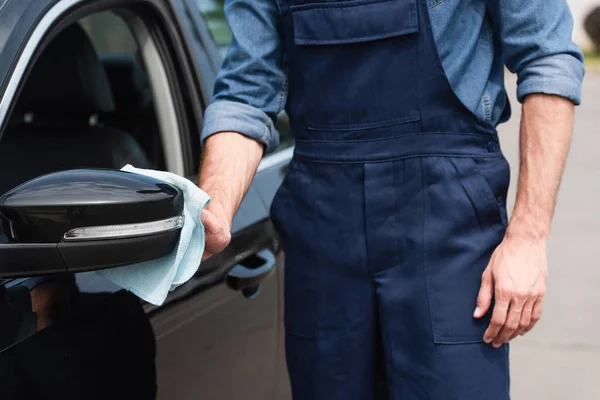 Cropped view of mechanic cleaning wing mirror of car outdoors — Stock Photo