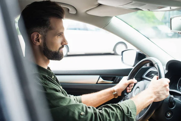 Seitenansicht eines brünetten Mannes, der Auto fährt — Stockfoto