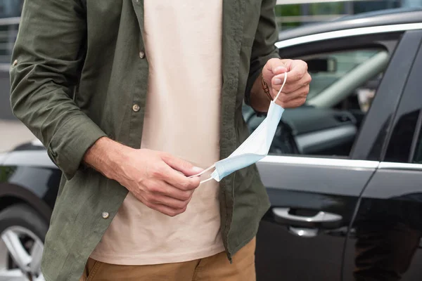 Cropped view of man holding medical man near car on blurred background — Stock Photo