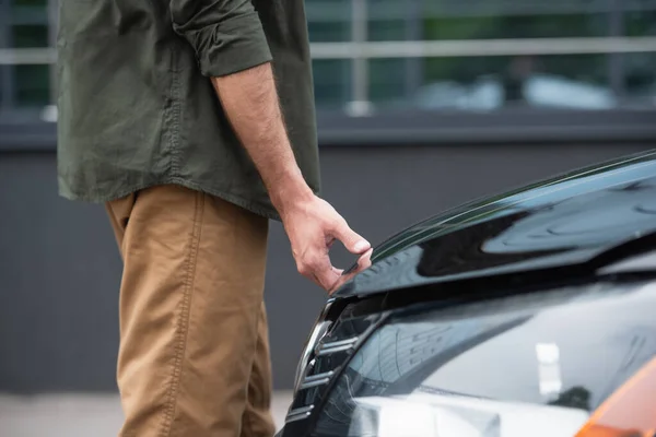 Vue recadrée de l'homme ouvrant le capot de la voiture à l'extérieur — Photo de stock