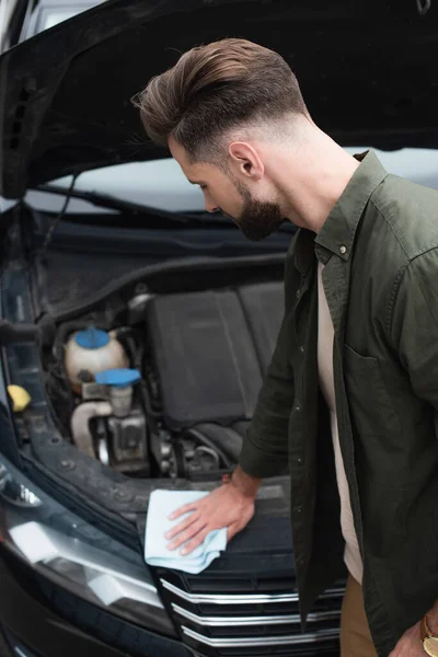 Side view of driver with rag cleaning car — Stock Photo