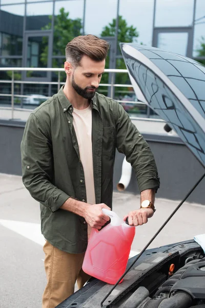 Homem abrir fluido lavador de pára-brisas perto de auto ao ar livre — Fotografia de Stock