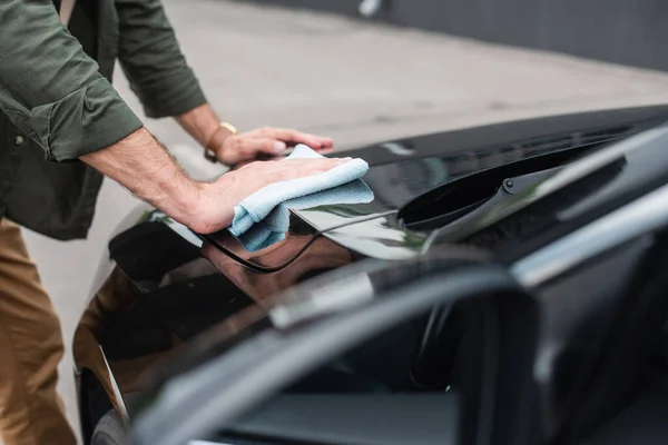 Cropped view of man waxing car outdoors — Stock Photo