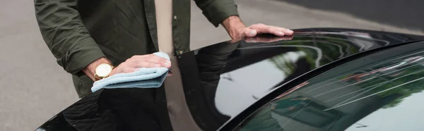 Cropped view of man with rag cleaning car, banner — Stock Photo