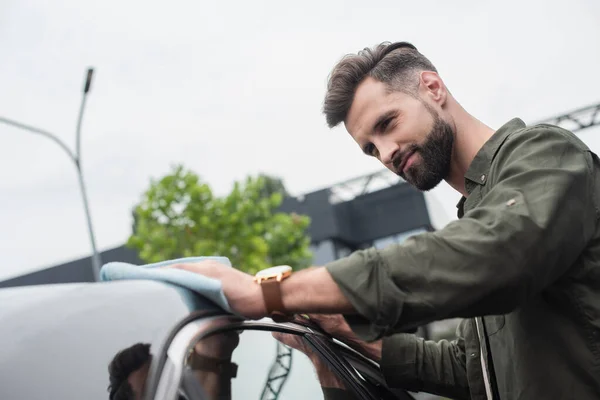 Young man in shirt cleaning car outdoors — Stock Photo