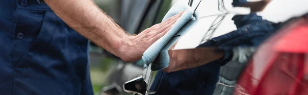 Cropped view of mechanic swiping car with rag, banner — Stock Photo