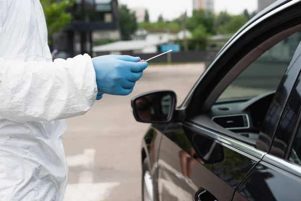 Cropped view of medical worker holding pcr test near car — Stock Photo