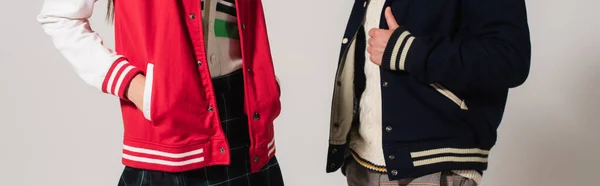Обрезанный вид на пару в модных куртках, изолированных на сером, баннер — стоковое фото