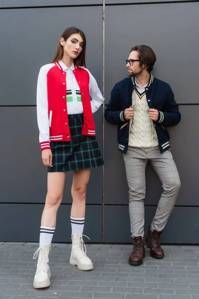 Trendy woman looking at camera near man in eyeglasses outdoors — Stock Photo