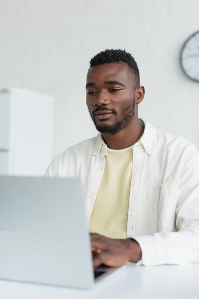 Joven afroamericano hombre usando borrosa portátil - foto de stock